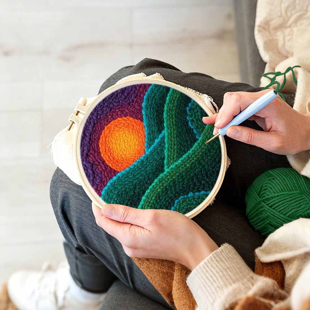 Creating handmade green rolling hills at sunset punch needle artwork