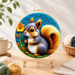 Finished grey and orange squirrel with golden tail needle felting displayed on a wooden easel