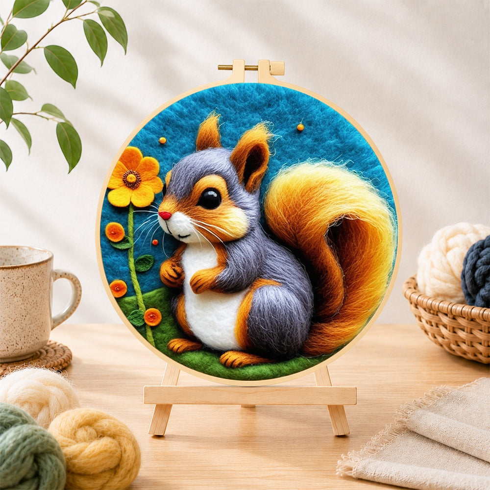 Finished grey and orange squirrel with golden tail needle felting displayed on a wooden easel