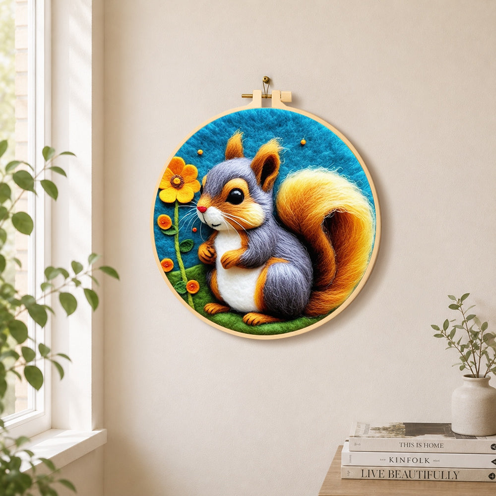 Grey and orange squirrel with golden tail needle felt wall art displayed in a bright home interior