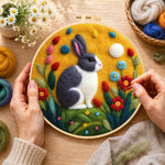 Creating the grey and white rabbit among flowers wool painting by hand with a felting needle