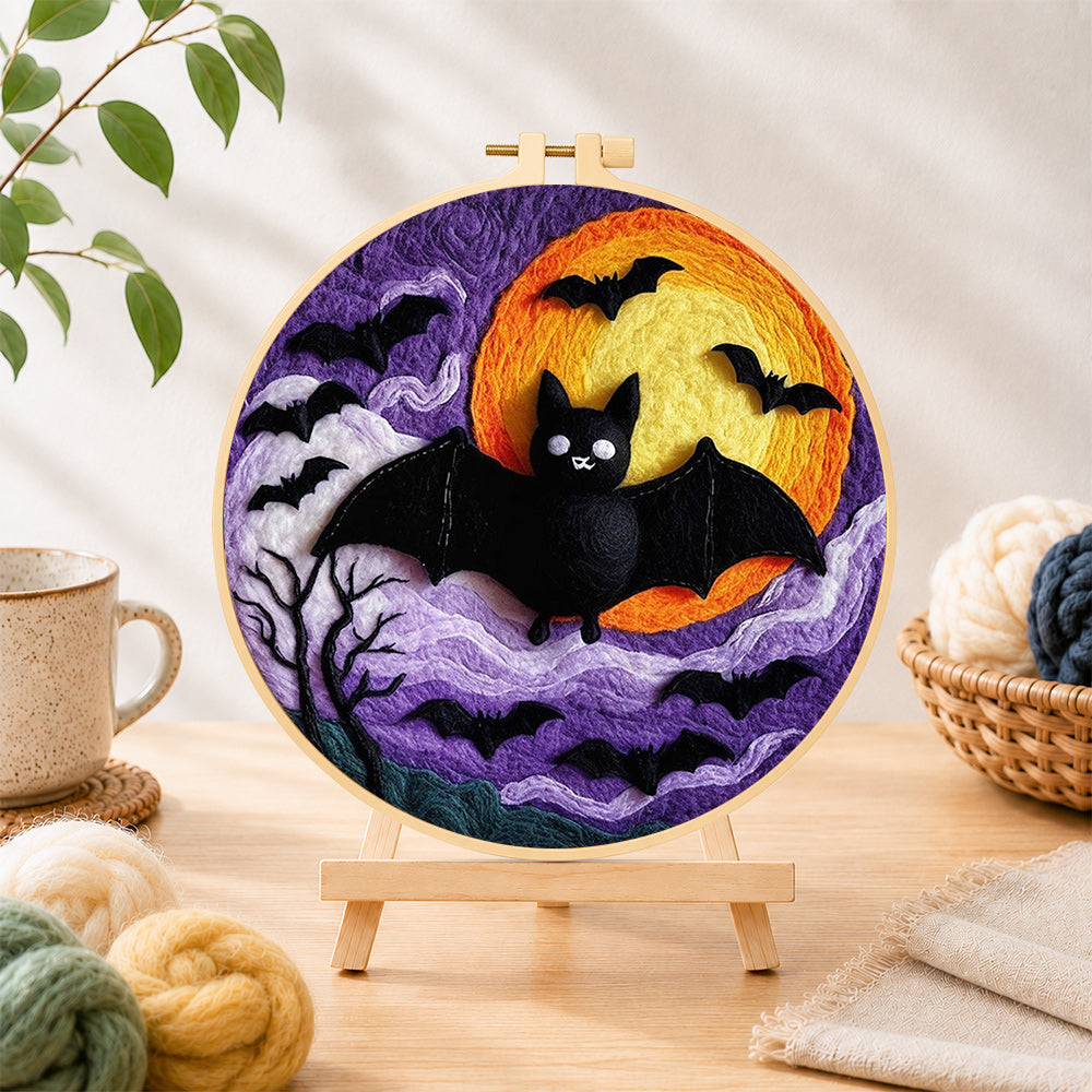 Finished halloween bats and spooky swirling clouds needle felting displayed on a wooden easel