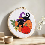 Halloween black cat and pumpkins punch needle artwork displayed on a table