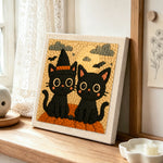 Halloween black cats with witch hat punch needle artwork displayed on a table