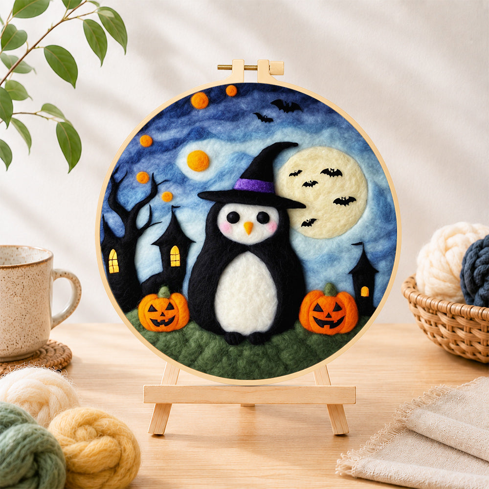 Finished halloween penguin in witch hat needle felting displayed on a wooden easel
