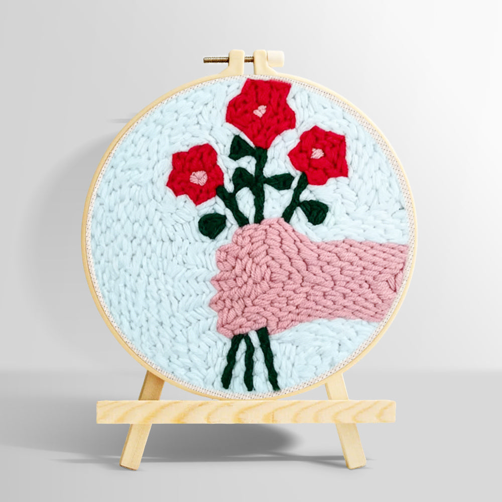 Hand holding red flowers punch needle kit for beginners