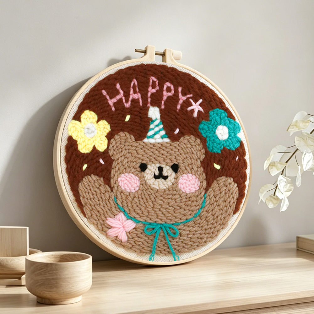 Happy bear with flowers punch needle artwork displayed on a table