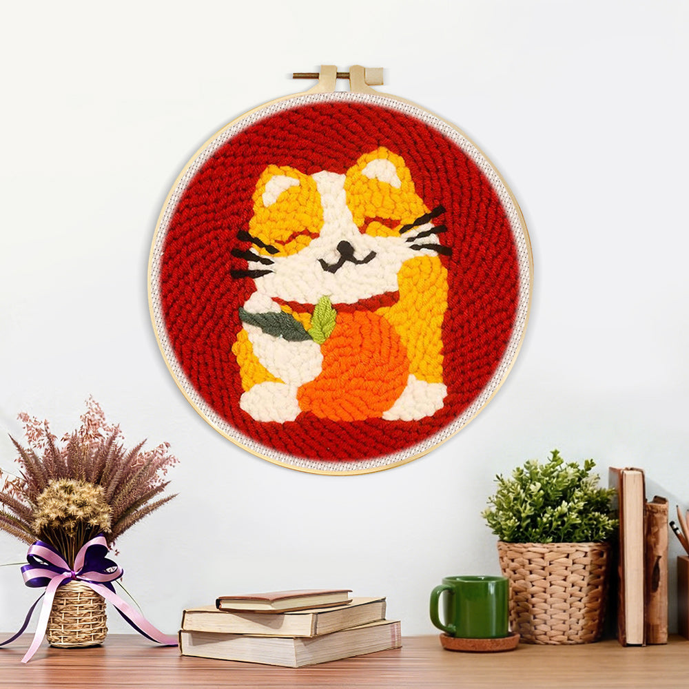 Finished happy cat holding an orange artwork displayed on a wall
