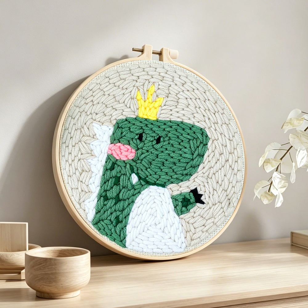 Happy crown dinosaur punch needle artwork displayed on a table
