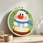Happy swing duck punch needle artwork displayed on a table
