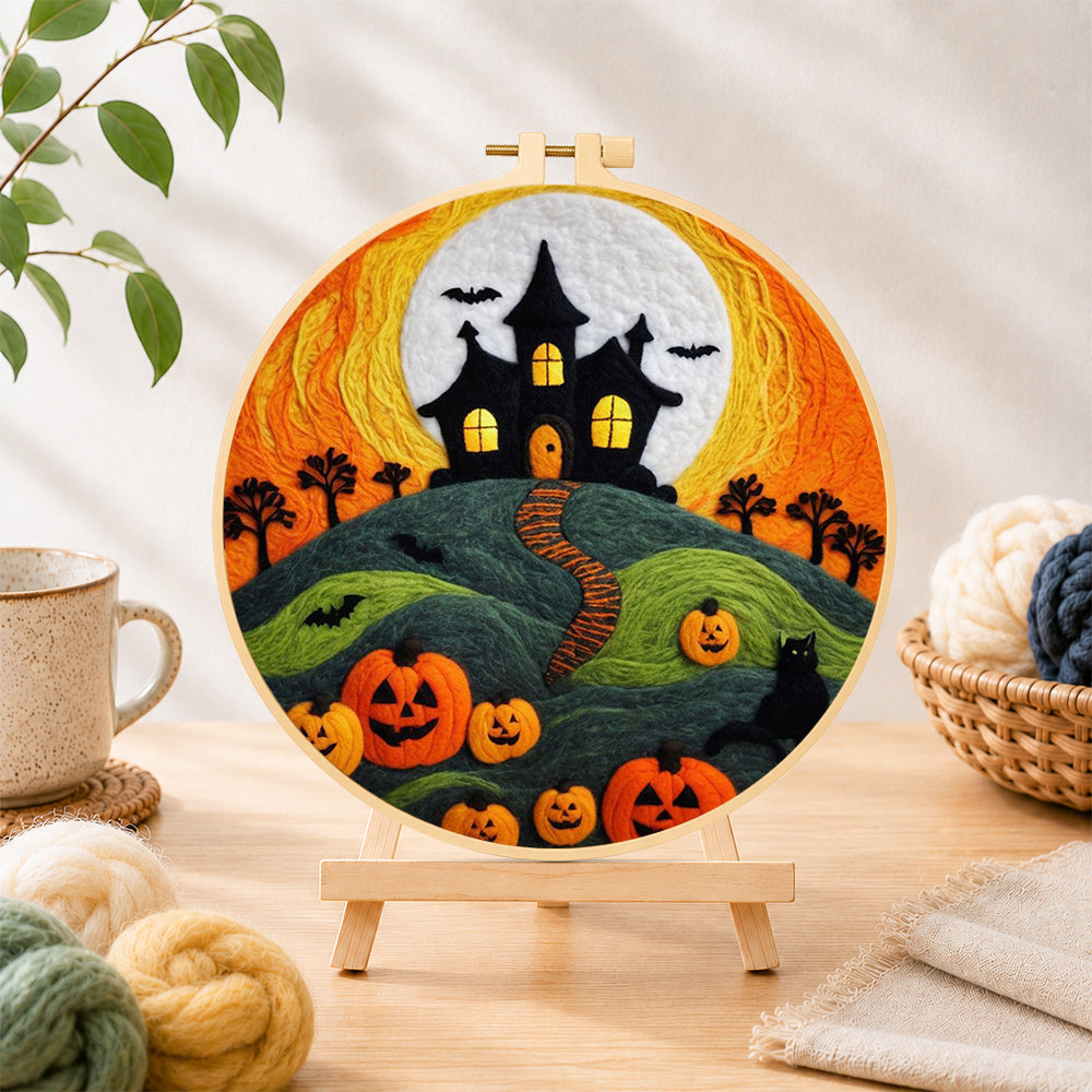 Finished haunted house on hill with pumpkins needle felting displayed on a wooden easel