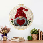 Finished heart-holding winter gnome artwork displayed on a wall