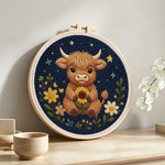 Highland cow and flowers at night punch needle artwork displayed on a table