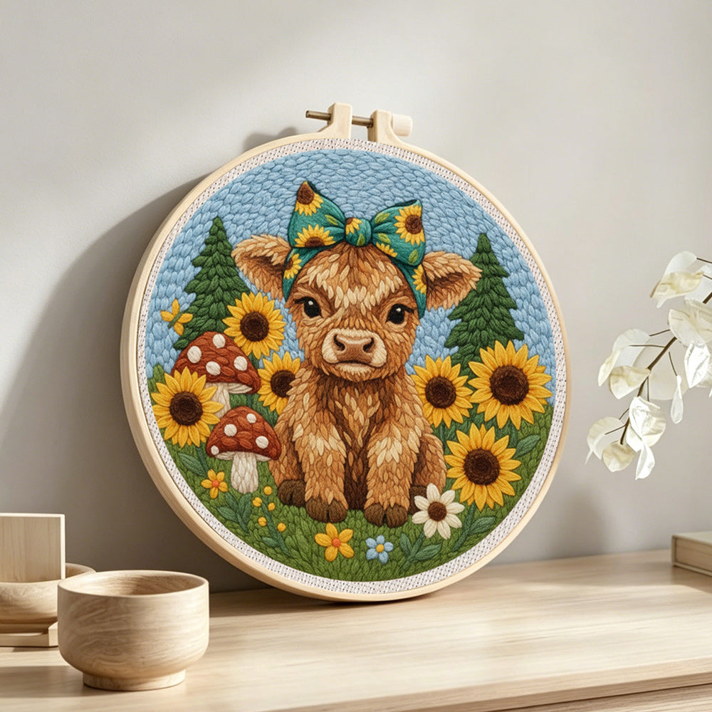 Highland cow and sunflowers on the green grass punch needle artwork displayed on a table