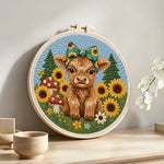 Highland cow and sunflowers on the green grass punch needle artwork displayed on a table