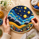 Creating the hills under the whimsical night sky wool painting by hand with a felting needle