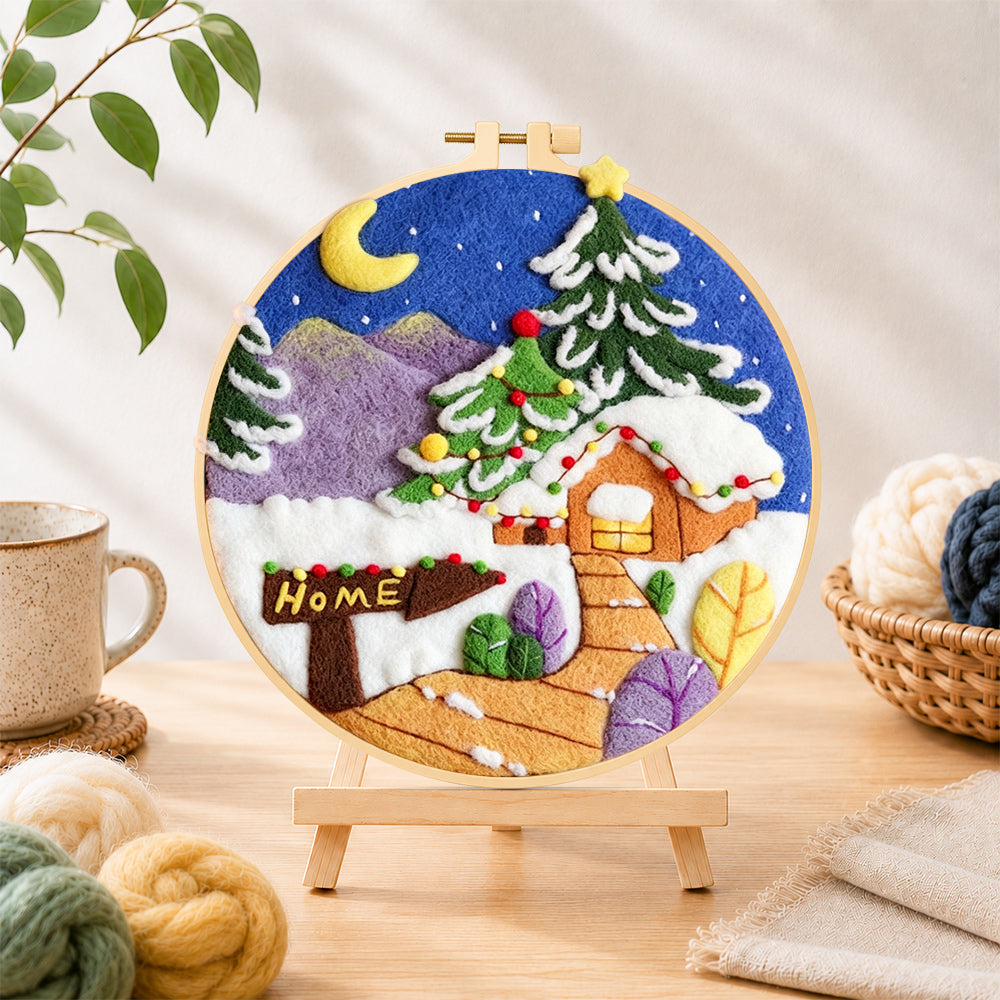 Finished "home" sign and christmas tree cabin needle felting displayed on a wooden easel