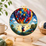 Finished hot air balloon and romantic couple needle felting displayed on a wooden easel