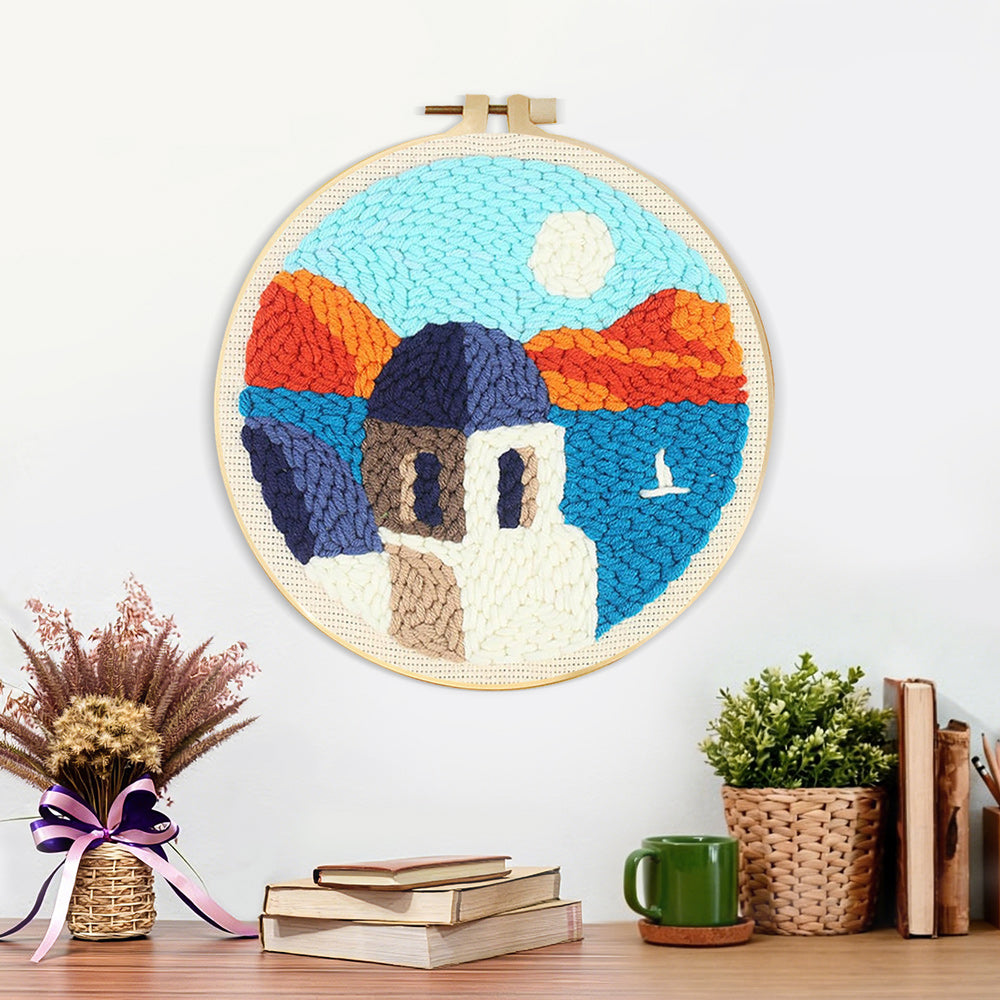 Finished house by the sea and mountains artwork displayed on a wall