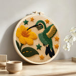Hummingbird and flower punch needle artwork displayed on a table