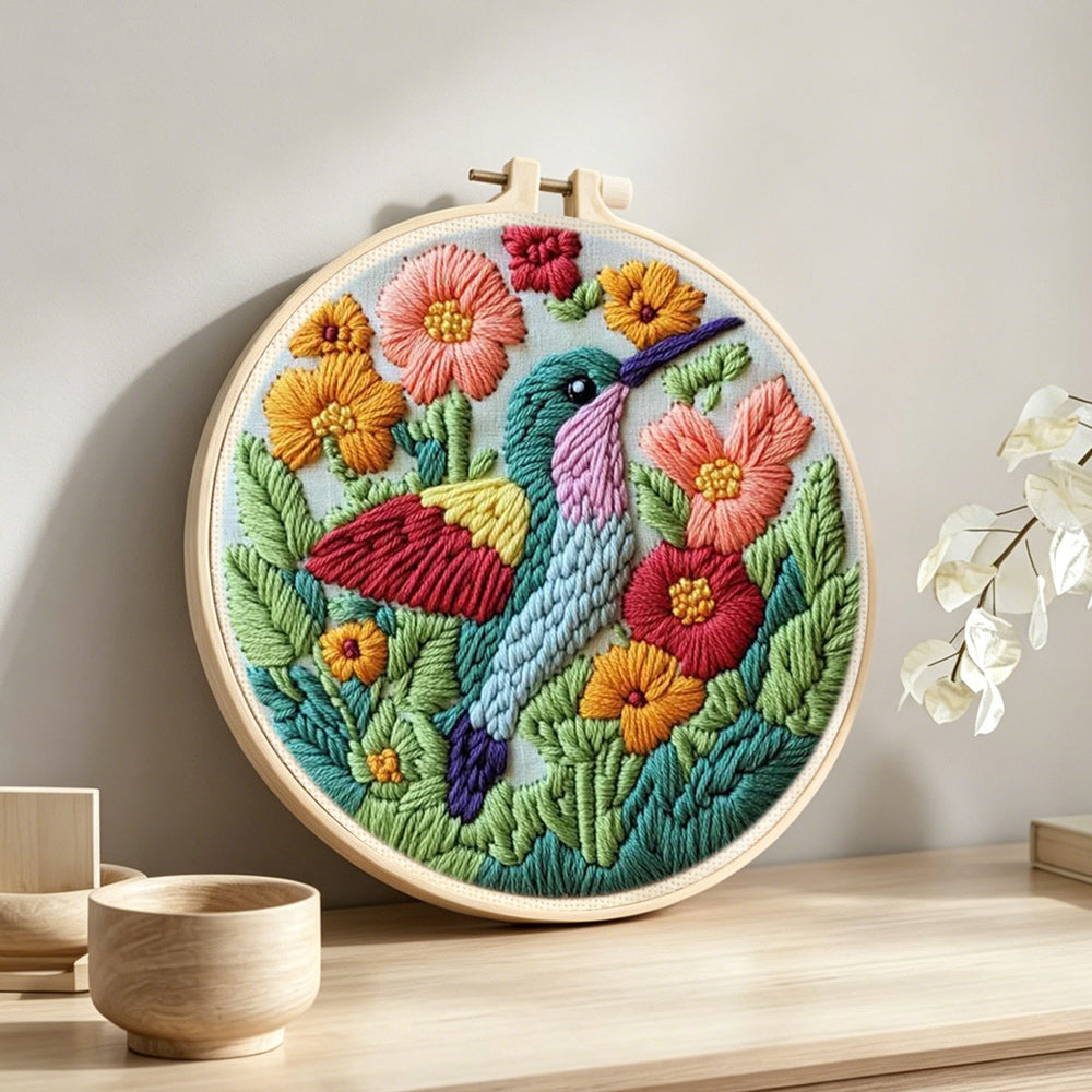 Hummingbird in the flower bushes punch needle artwork displayed on a table