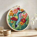 Hummingbird in the flower bushes punch needle artwork displayed on a table