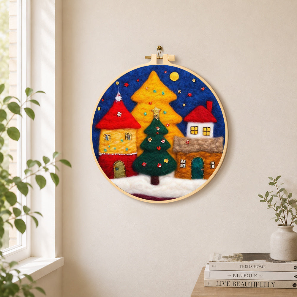 Illuminated christmas village needle felt wall art displayed in a bright home interior
