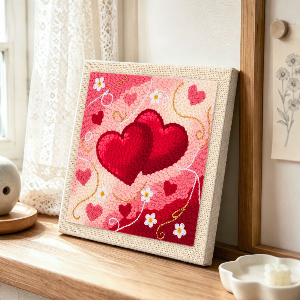 Intertwined hearts punch needle artwork displayed on a table