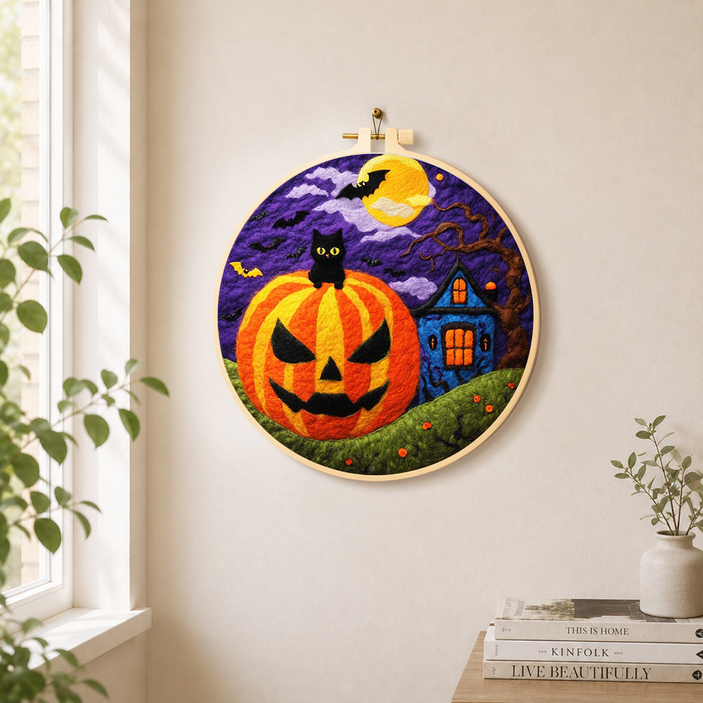 Jack-o'-lantern and haunted house needle felt wall art displayed in a bright home interior