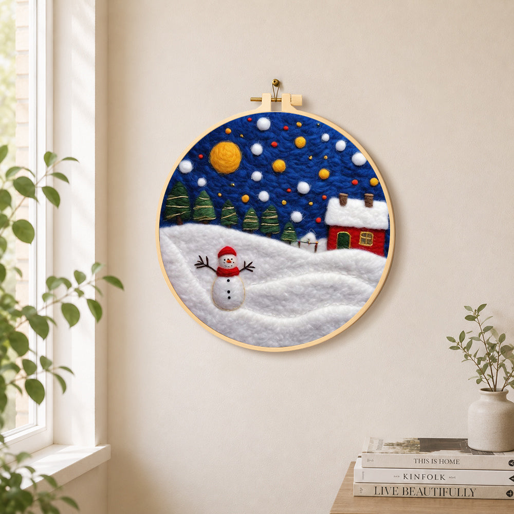 Jolly snowman and red winter cottage needle felt wall art displayed in a bright home interior
