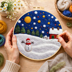 Creating the jolly snowman and red winter cottage wool painting by hand with a felting needle