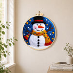Jolly snowman with top hat and scarf needle felt wall art displayed in a bright home interior