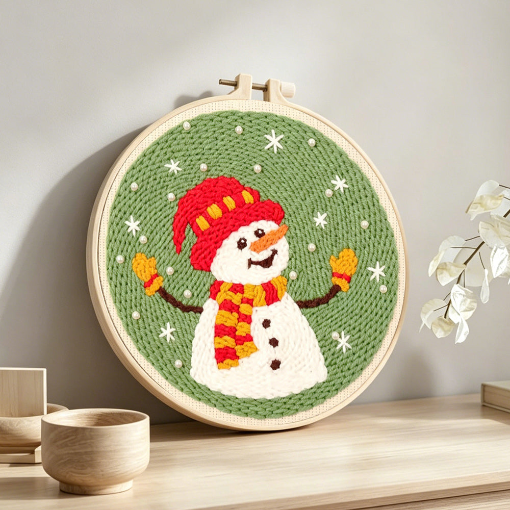 Joyful snowman in winter hat punch needle artwork displayed on a table