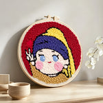 Kawaii "girl with a pearl earring" parody punch needle artwork displayed on a table