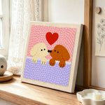 Kissing puppies with red heart punch needle artwork displayed on a table