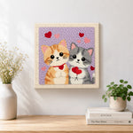 Finished kittens holding hearts artwork displayed on a wall