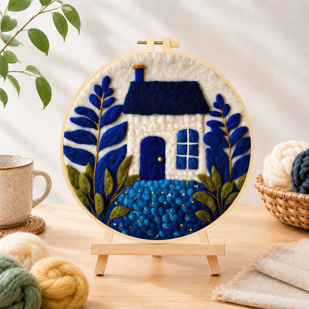 Finished klein blue and white cottage needle felting displayed on a wooden easel