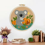 Finished koala and pumpkins in autumn artwork displayed on a wall