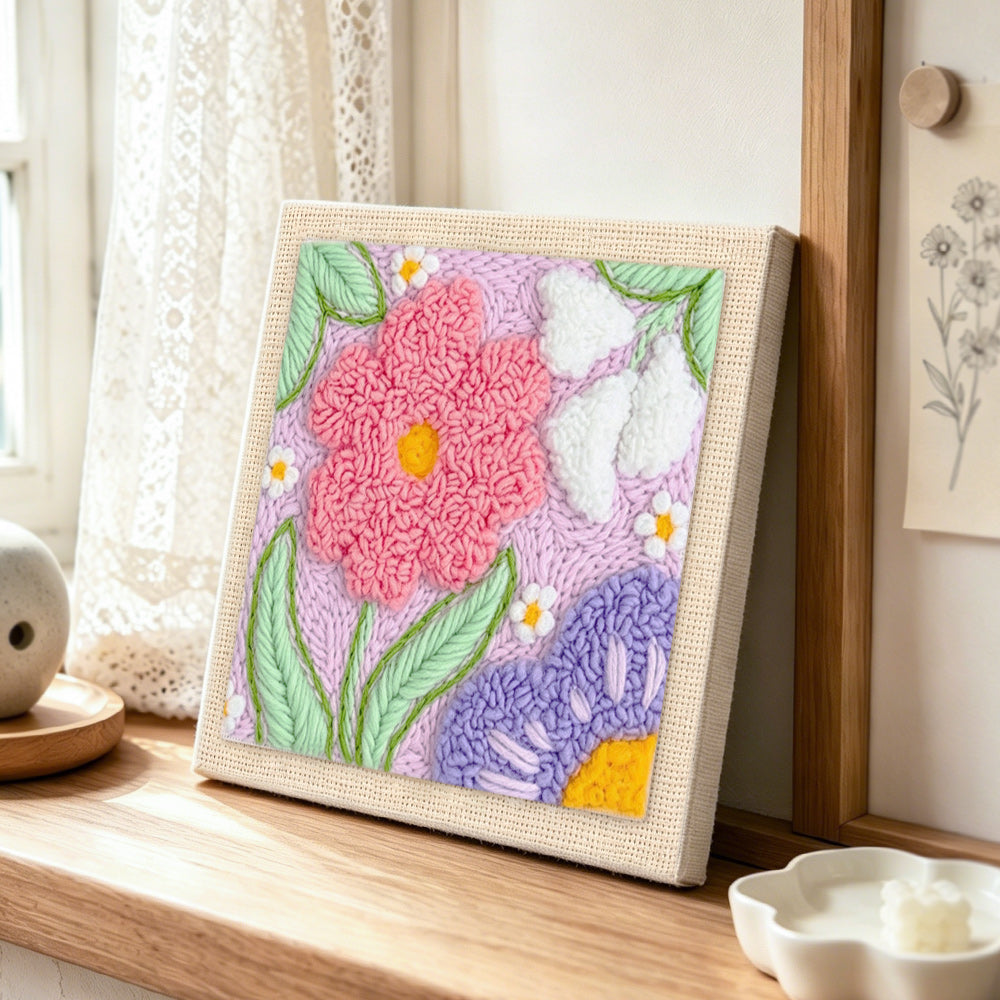 Large pink and purple flowers punch needle artwork displayed on a table