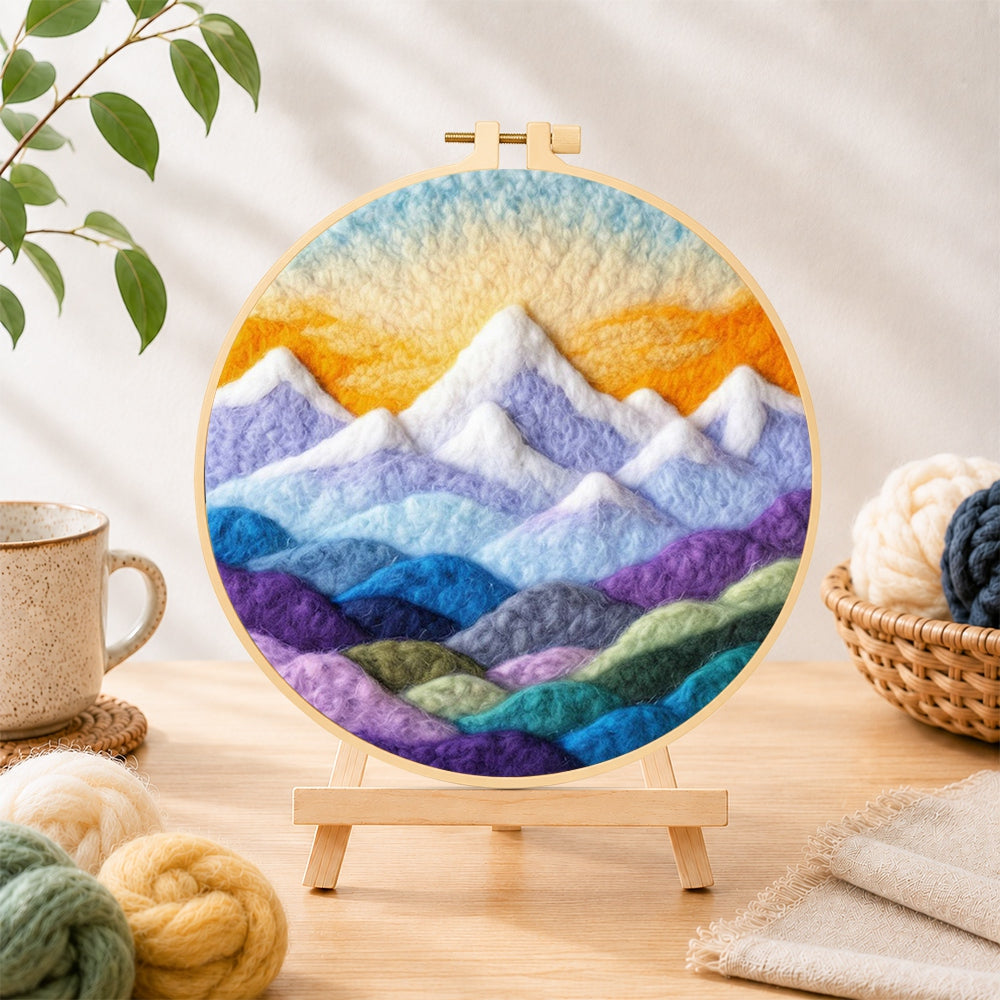 Finished layered colourful mountain peaks at sunrise needle felting displayed on a wooden easel