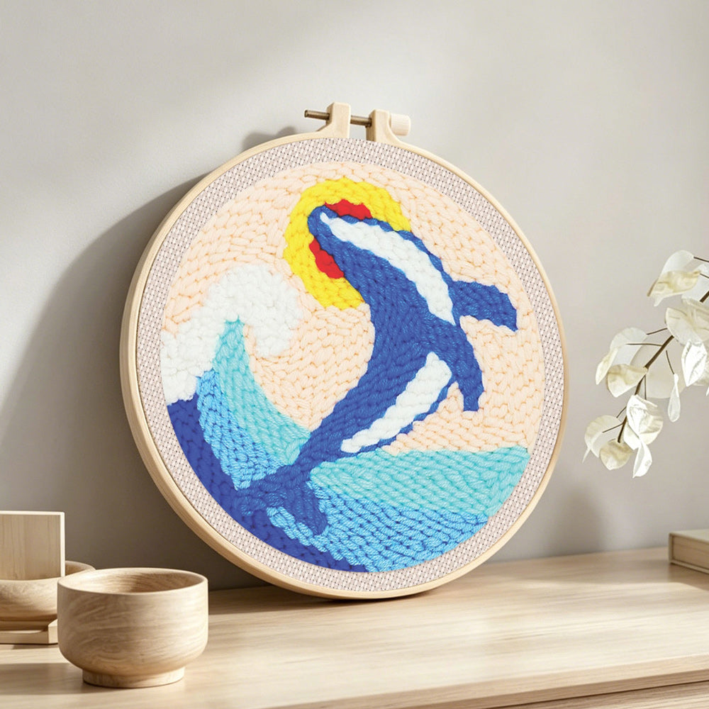 Leaping dolphin and waves punch needle artwork displayed on a table