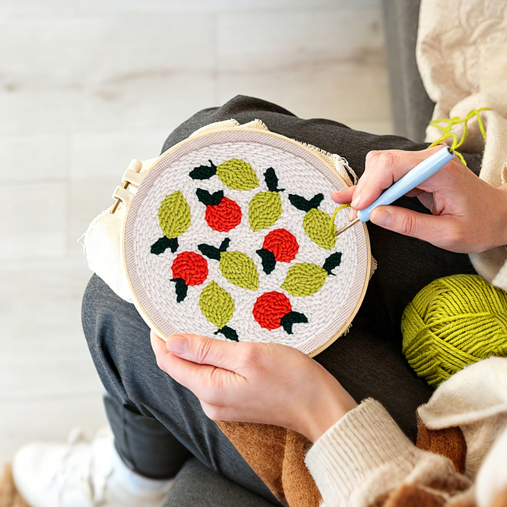 Creating handmade lemons and red berries punch needle artwork