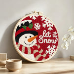 “Let it snow” snowman with scarf punch needle artwork displayed on a table
