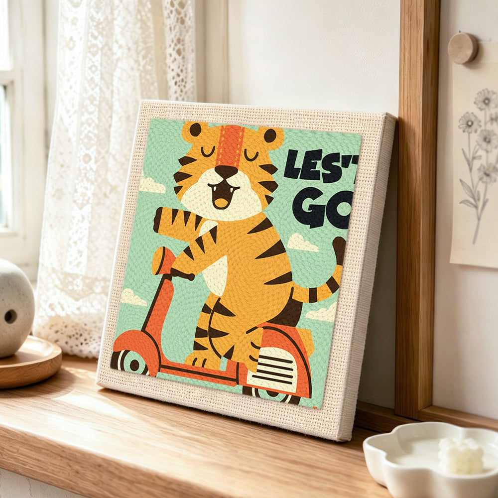 "LET'S GO" tiger on scooter punch needle artwork displayed on a table