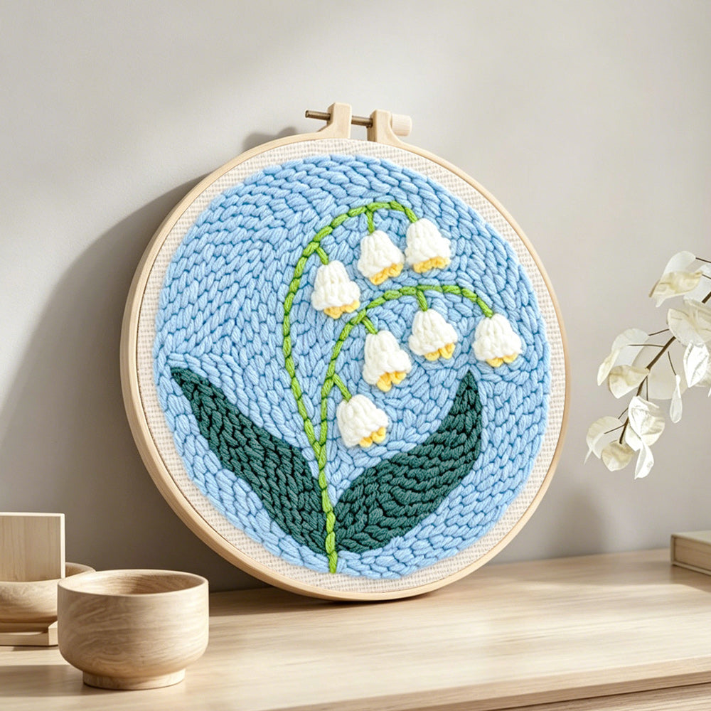 Lily of the valley punch needle artwork displayed on a table