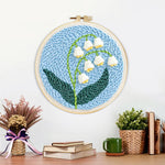 Finished lily of the valley artwork displayed on a wall