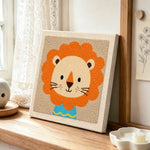 Lion in blue shirt punch needle artwork displayed on a table