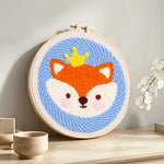 Little crown fox punch needle artwork displayed on a table