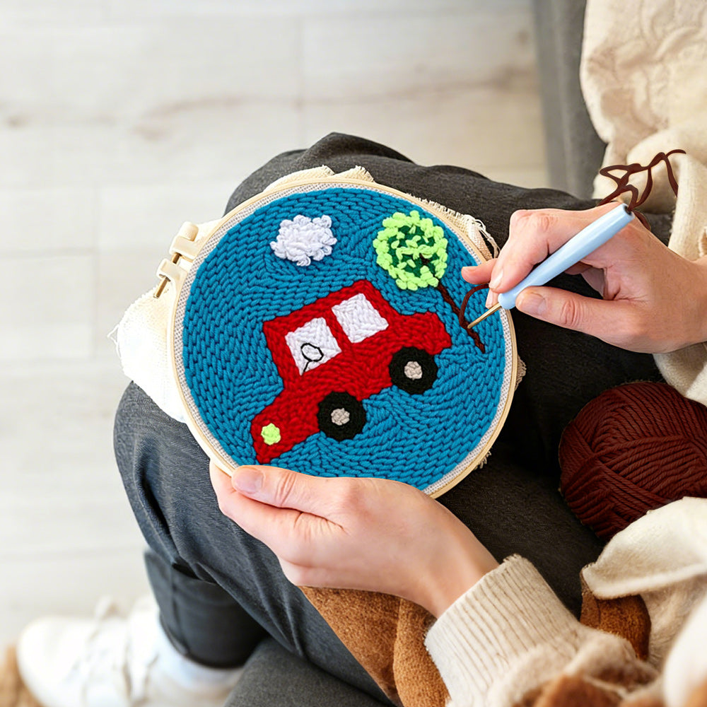 Creating handmade little red car with tree punch needle artwork