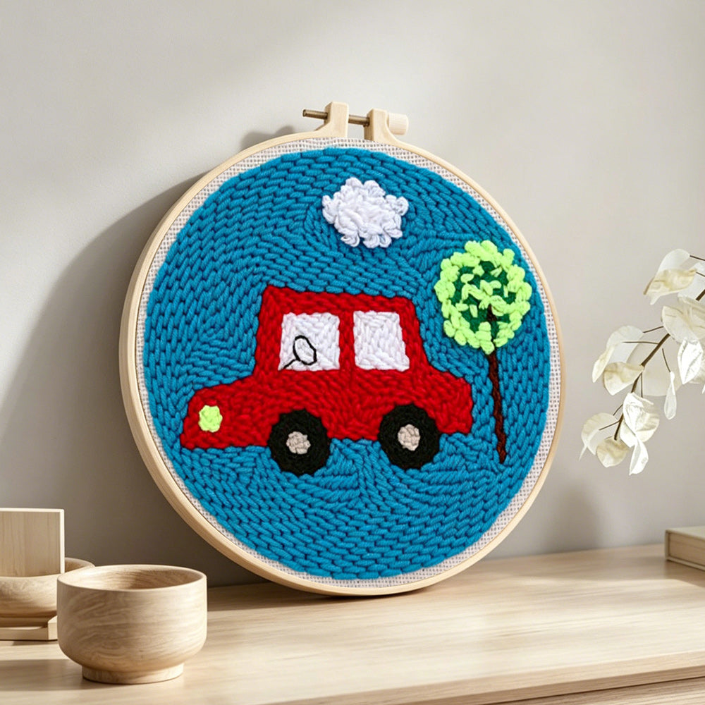 Little red car with tree punch needle artwork displayed on a table